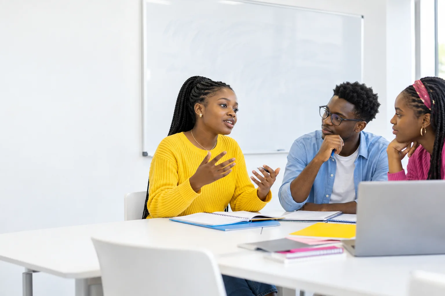Students debating in a bright white seminar classroom