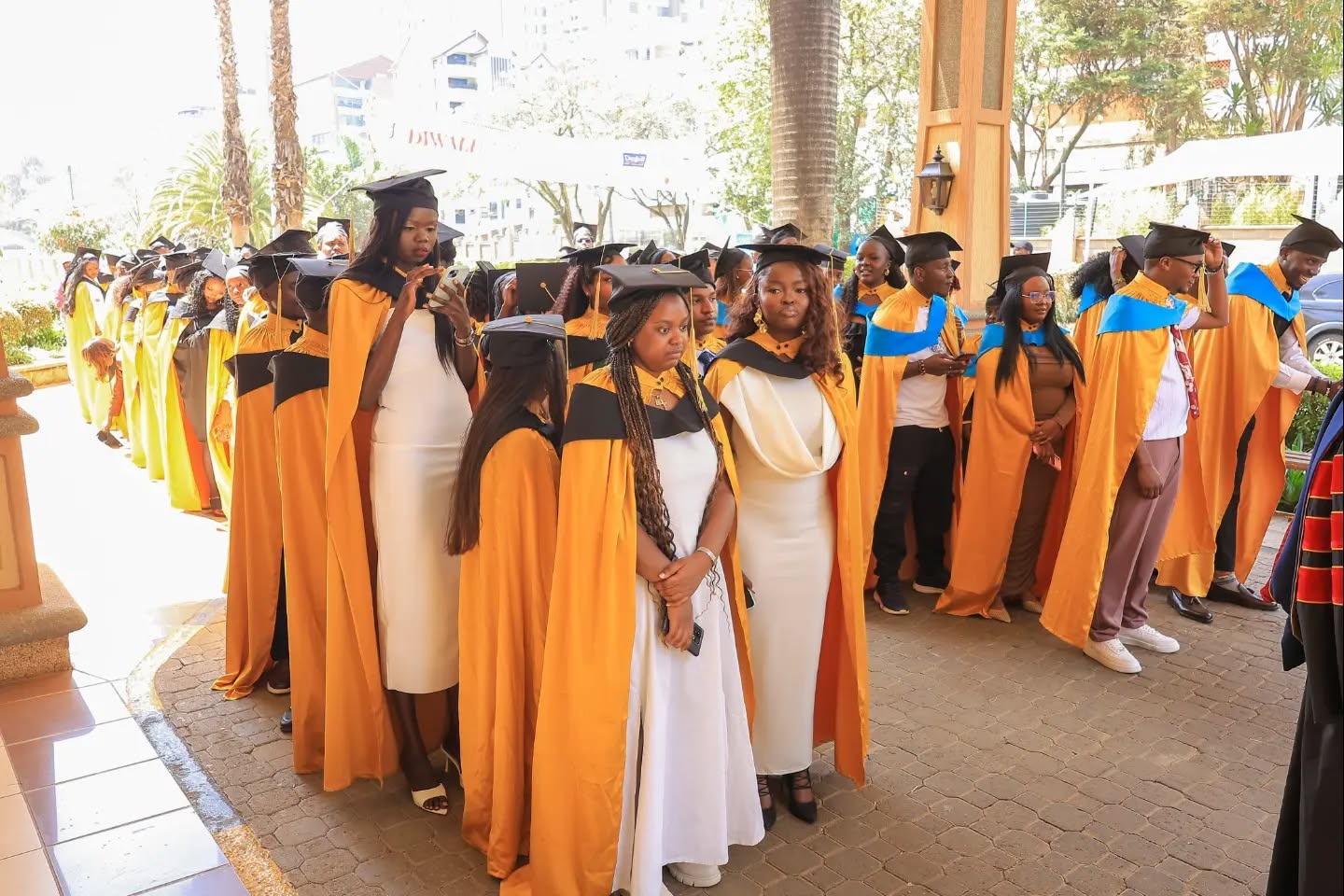 Graduates in gold and blue gowns preparing for the ceremony